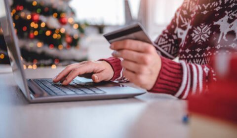 Women Wearing Red Sweater Shopping Online And Using Credit Card At Home Office
